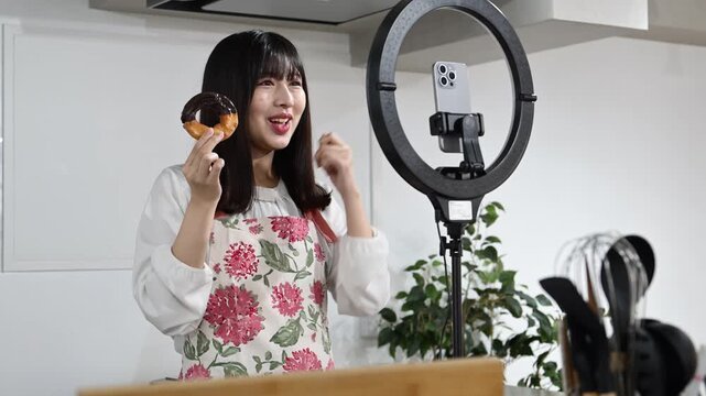 ドーナツを紹介しながら動画配信をする20代の日本人女性