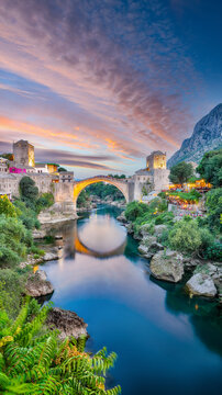 Amazing Skyline of Mostar with the Mostar Bridge, houses and minarets, at sunset.