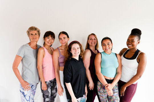 Diverse women of mixed ages and ethnicities standing together smiling