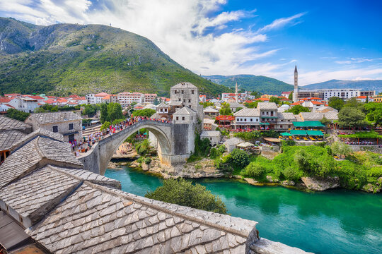 Awesome Skyline of Mostar with the Mostar Bridge, houses and minarets, during sunny day.