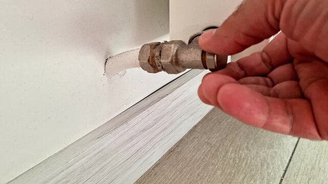 A hand adjusts a radiator valve connection to ensure a secure fit and proper heating system performance. Ideal footage for home maintenance, plumbing, HVAC repair, and DIY renovation projects