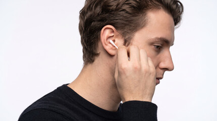 Fototapeta premium Side view of a person using a cotton bud to clean their ear, only visible from the neck up, studio lighting with clean white backdrop