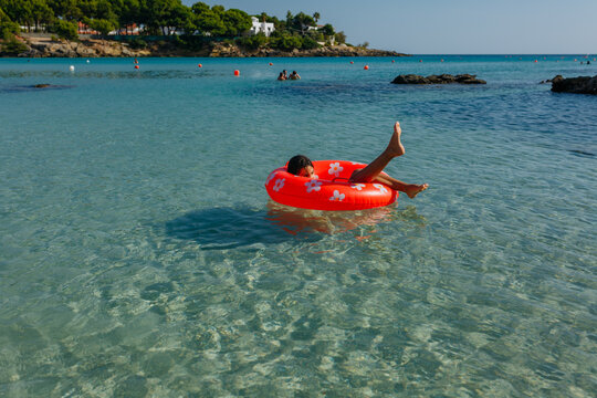 Young girl floating on swimming ring on a sunny day in the clear sea