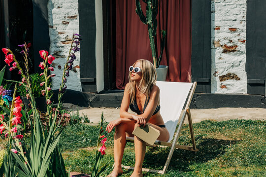 woman in swimsuit lounging in garden during summer heatwave