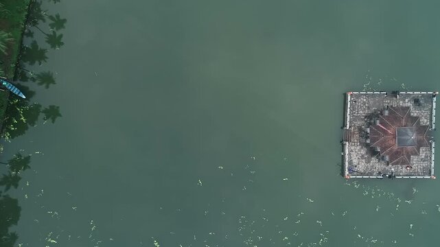Aerial view of serene Kere Basadi temple floating within varanga Lake heritage landscape scenery