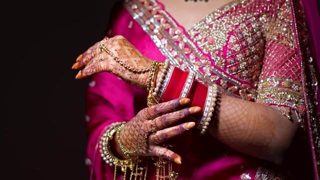 Indian bride hands with henna and bangles. Traditional wedding jewelry in Delhi NCR.