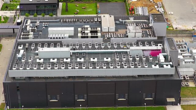 Aerial view of a modern data center building, highlighting the numerous hvac units on the roof for cooling the powerful gpu servers inside
