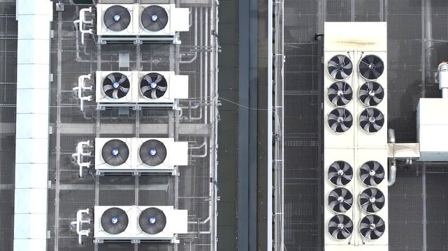 Aerial perspective of numerous industrial air conditioning units on the rooftop of a modern ai data center cooling high performance gpu servers