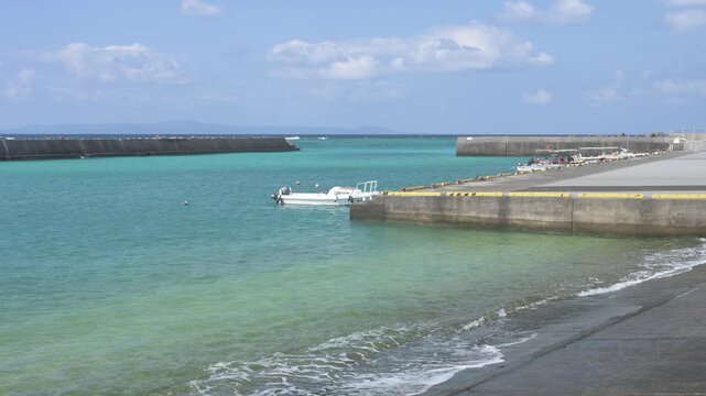 青空とエメラルドグリーンの海が美しいのどかな港の風景