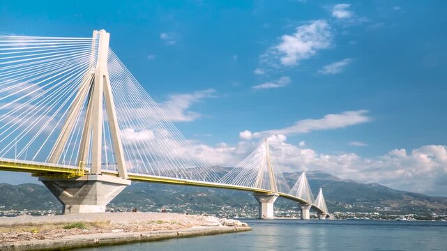 Rio Antirrio Bridge Landscape Timelapse, Clouds Motion in Blue Sky and Maritime Traffic, Low Angle Shot, Wide View