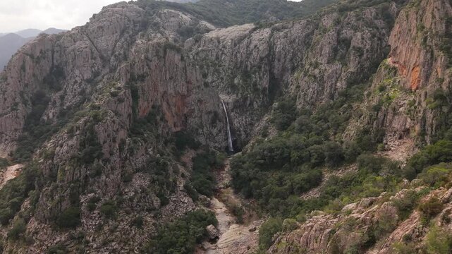 Cascades Flow Into Natural Granite Pools. Piscina Irgas Waterfall In The Municipality Of Villacidro, South Sardinia, Italy. Aerial Drone Shot