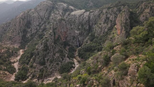Flying Towards Cascades Of Piscina Irgas Waterfall Against Granite Walls In Sardinia, Italy. Aerial Forward Shot