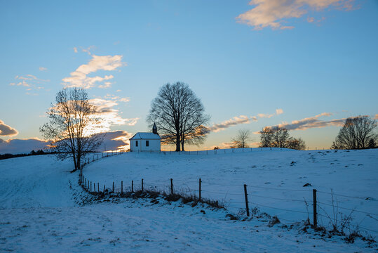 wintry field with small chapel Altenburg at sunset. landscape near Aschbach