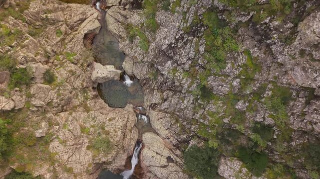 Piscina Irgas Waterfall Plunges Into A Deep, Jade-green Natural Pool Near Villacidro In Sardinia, Italy. Aerial Topdown Shot