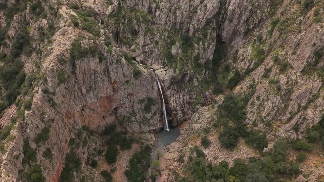 Piscina Irgas Waterfall With Natural Pool Surrounded By Granite Rock Formations In The Monte Linas Area Near Villacidro, Sardinia, Italy. - aerial shot