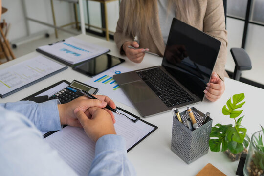 Asian businesswoman showing information on laptop