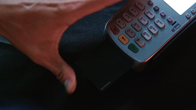 Illegal hacker cracking a bank card pin number using a credit card terminal in a dark hideou
