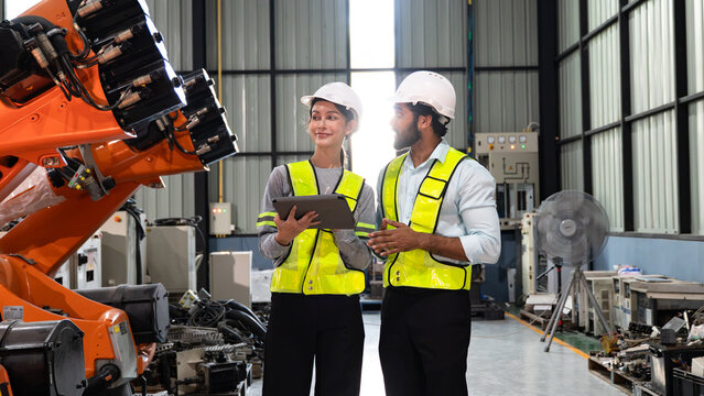 Industrial engineers carrying out inspection activities while reviewing production quality in an automated manufacturing environment.