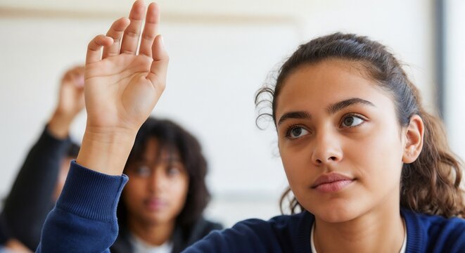 Student raising hand in bright classroom, actively participating during lesson, showing engagement. Focused student raising hand, eager to ask question or contribute. Concept for student raising hand,