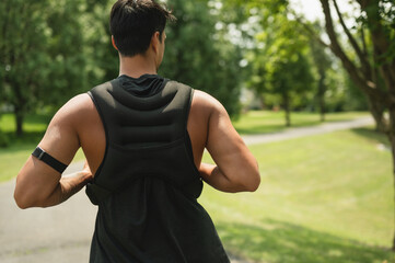 Fototapeta premium Athletic man training outdoors with a weighted vest