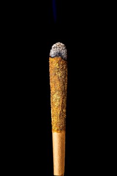 Lit cannabis pre roll coated in golden kief