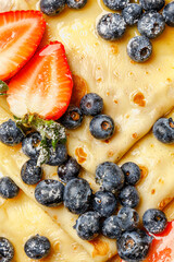 Close-up macro shot of pancakes with blueberries and strawberries © Cavan