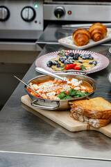 Shakshuka in a pan in a restaurant kitchen © Cavan