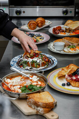 A female chef is preparing breakfasts in a restaurant. © Cavan