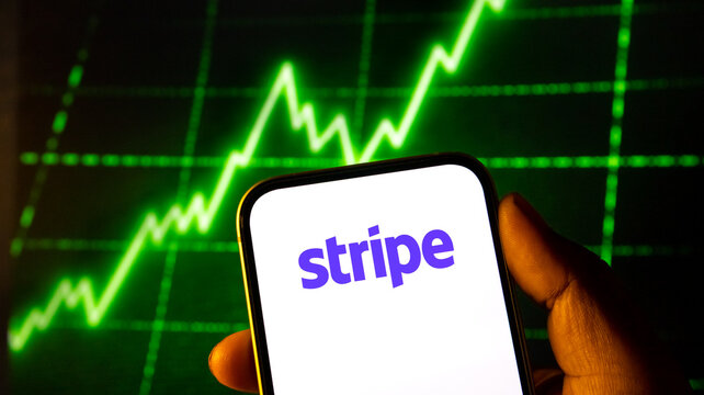 Smartphone displaying stripe logo with stock market growth chart background representing financial platform.
