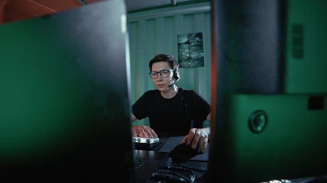 A young hacker operates computer equipment in a hidden container workspace.