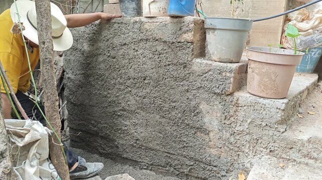 Mason Smoothing Fresh Cement Wall Render Using a Small Wooden Float