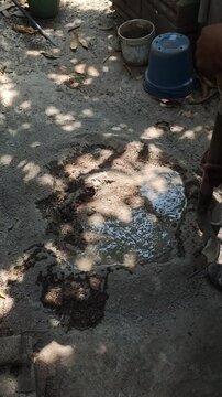 Pouring Water from Tray into Sand and Cement Mixture for Mortar Prep