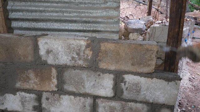 Leveling and Smoothing Fresh Cement Patch on Brick Wall
