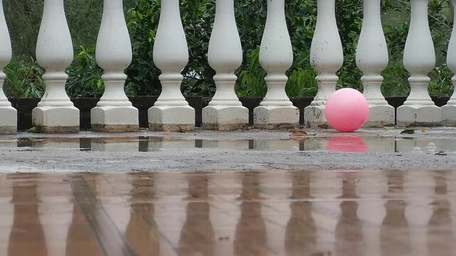 Raindrops Splashing on Rooftop Floor Near Pink Toy Ball