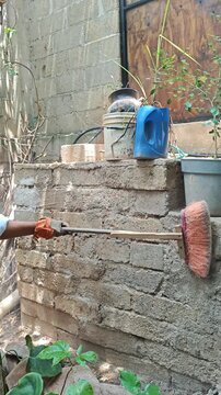 Mason Sweeping Dust off Old Wall with Broom Before Plastering