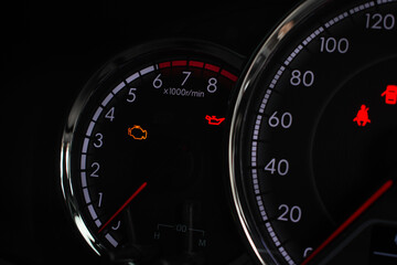 Fototapeta premium Close-up of car tachometer showing illuminated check engine and oil pressure warning lights.