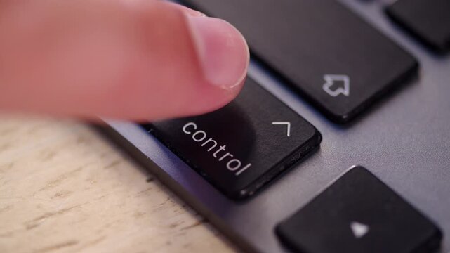 Person pressing control key on a laptop close up. Command button on a computer keyboard. Hot keys.