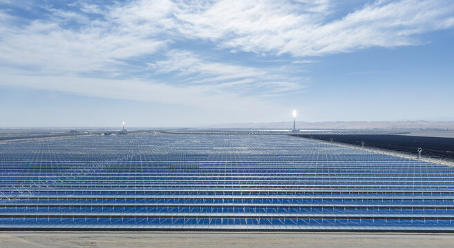 Bird's-Eye View of Linear Fresnel Concentrated Solar Power Station with Glowing Molten Salt Towers in Desert