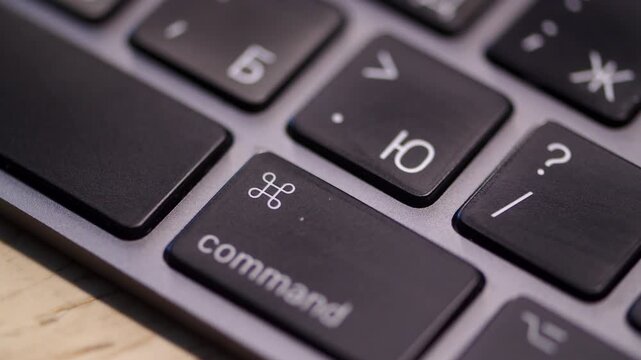 Person pressing command key on a laptop close up. Command button on a computer keyboard. Hot keys.