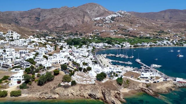Establishing aerial view of the town and port of Livadi at Serifos island, Cyclades, Greece, during a sunny summer day