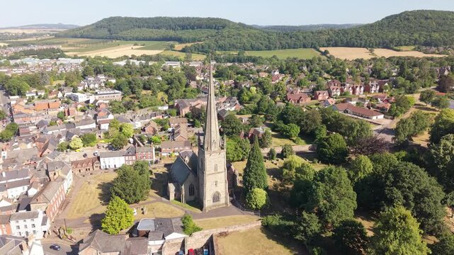 Smooth drone orbit around the historic parish church in Ross-on-Wye, revealing the charming market town, surrounding countryside and wooded hills on a sunny summer day in Herefordshire, England, Unite
