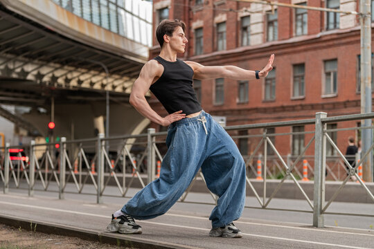 muscular man is dancing energetically on a city street.