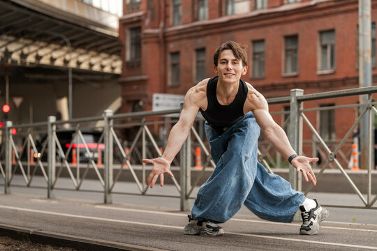 Young man in baggy jeans dancing on a city street