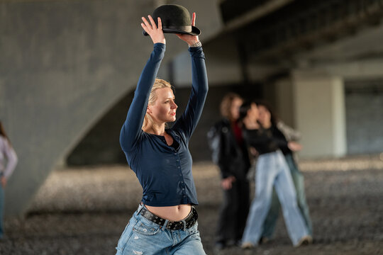 Female dancer strikes a pose with a bowler hat