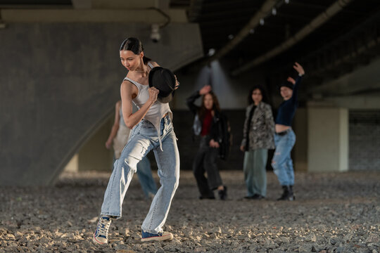 Woman performs street dance routine with hat