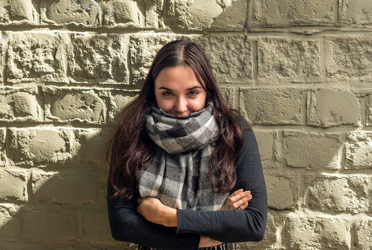 Old weather concept featuring a young brunette woman wrapped in
