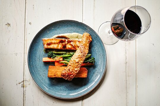 Overhead view of a pork belly dinner with red wine