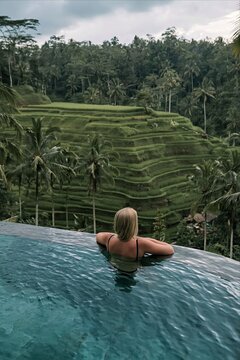 Woman enjoying view of rice terraces from infinity pool