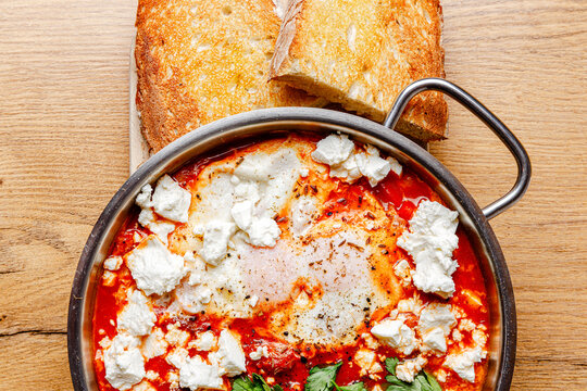 Shakshuka with cheese in a skillet (close-up, isolated image)