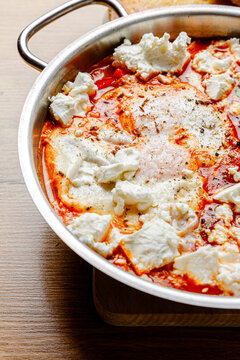 Shakshuka with cheese in a skillet (close-up, isolated image)